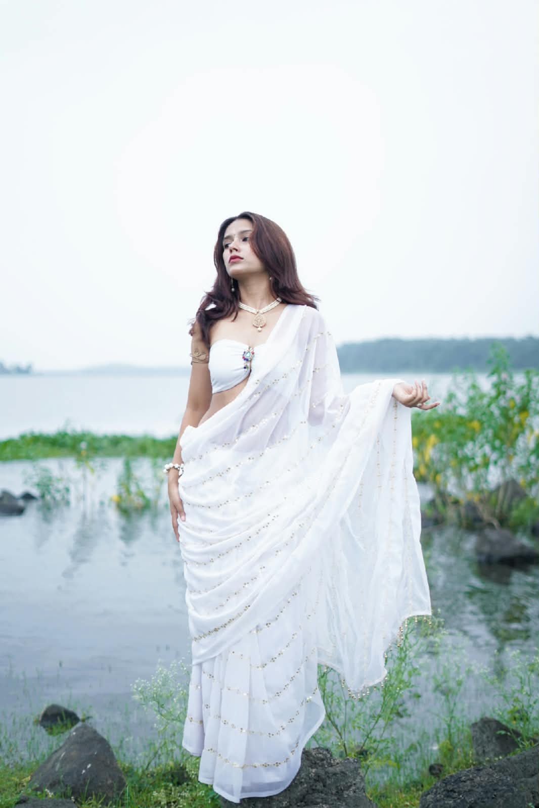 Janvi Saxena in a white drape saree by the water