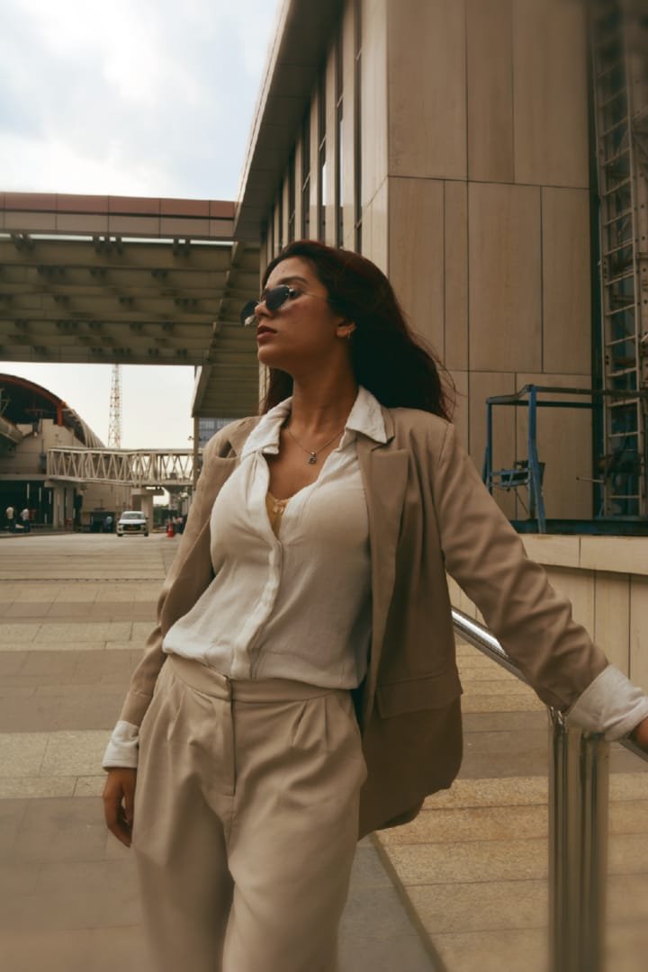 Janvi Saxena in a beige blazer walking through an urban street